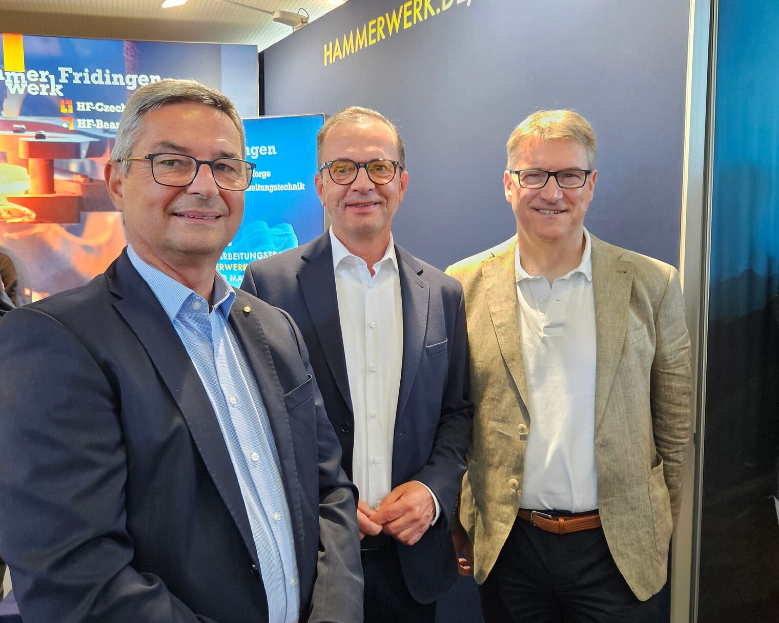Drei Männer posieren gemeinsam am Messestand von Hammerwerk Fridingen auf der Ausbildungsbörse PROTUT in Tuttlingen.